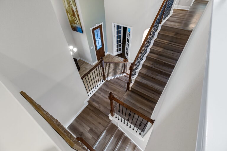 a modern staircase with dark wood-look flooring and a railing with metal balusters