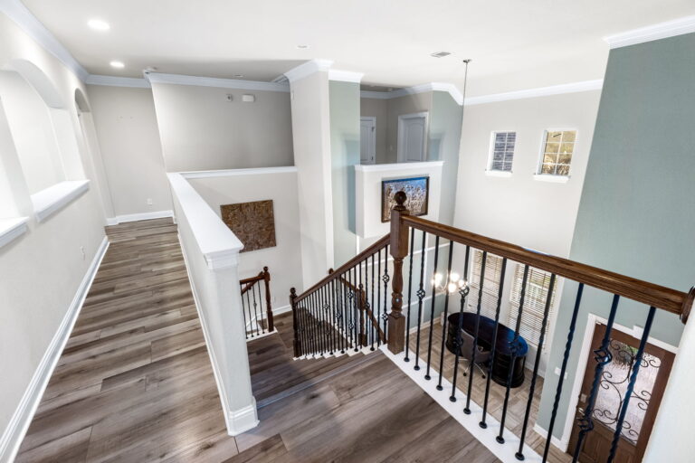 a modern staircase with dark wood-look flooring and a railing with metal balusters
