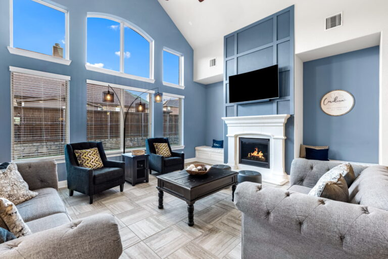a stylish living room, with its dramatic blue accent wall and vaulted ceilings