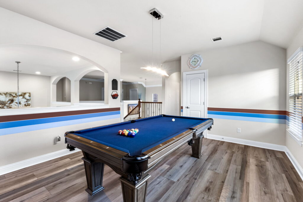 a brightly lit game room featuring a pool table
