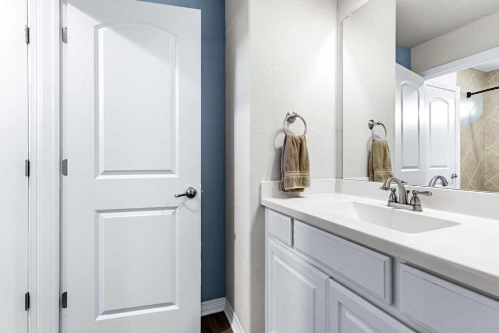 a modern bathroom featuring a white vanity cabinet with a white countertop