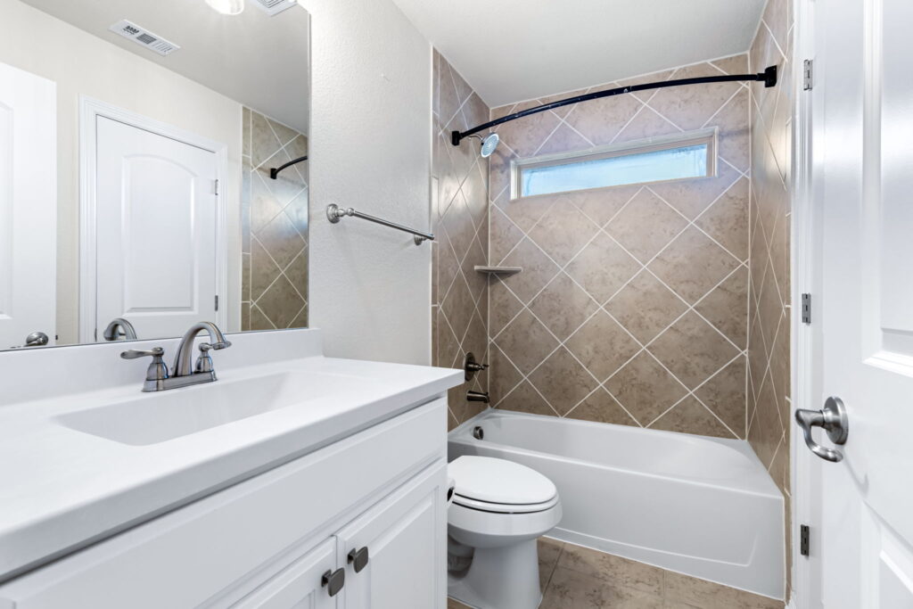 a modern bathroom featuring a white vanity cabinet with a white countertop